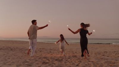 parents and a kid walking on a beach