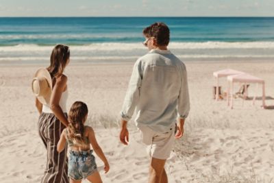parents and a kid walking on a beach