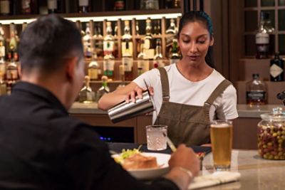 Woman making a drink at a bar