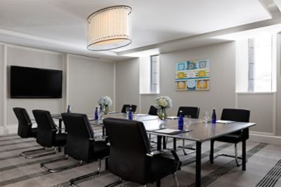 Grant -  Meeting Venue -  modern room with chrome and crystal chandelier and 75-inch built-in monitor.
