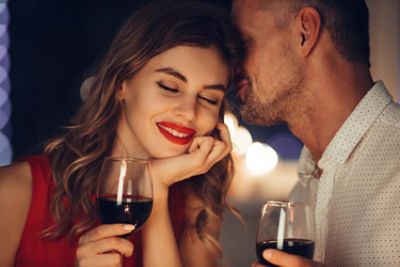 handsome couple at dinner table with red wine