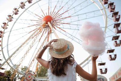 women looking at ferries wheel with cotton candy in hand