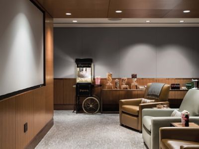 the cinema suite at The Langham Chicago with lounge chairs and popcorn machine.