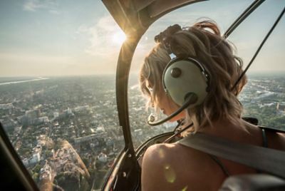 woman in helicopter overlooking the city skyline below
