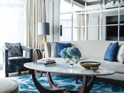 The Harmony Suite living room features a sofa in soft beige and armchair in blue velvet for a serene, peaceful feel.