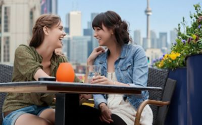 Two women having a drink at a sidewalk cafe